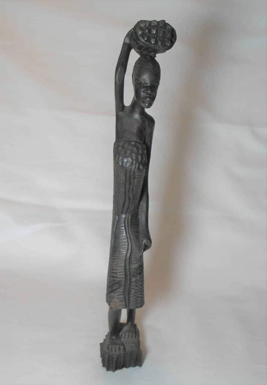 | Casa do Colecionador Escultura esculpida e talhada em madeira no estilo Africana carregando seus pertences. Rico em detalhes. --- importado
