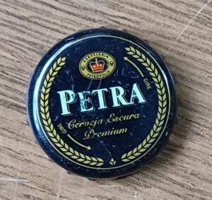 Embalagem tampinha cerveja Petra Premium escura.