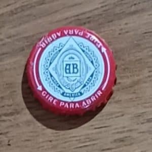 Tampinha de cerveja AB beirada vermelha, pra girar.